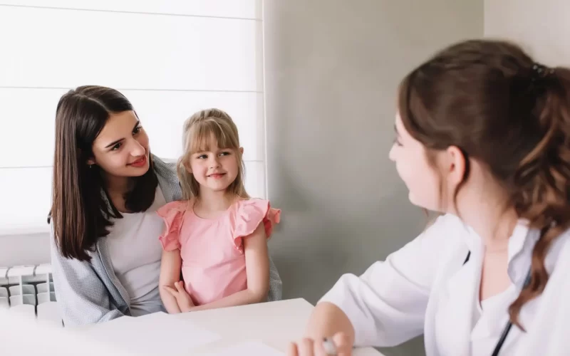 mother-or-sister-with-small-girl-visiting-family-doctor-in-the-clinic.webp